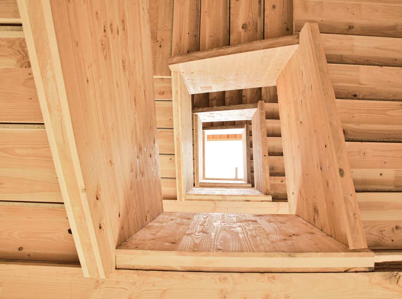 Interior de edificio con estructura CLT de madera laminada cruzada fabricado por Madergia, con escaleras y forjados de madera vista