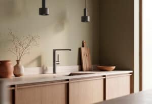 Grifo monomando de cocina en acabado grafito de la marca Tres, instalado sobre encimera de mármol en cocina de estilo contemporáneo