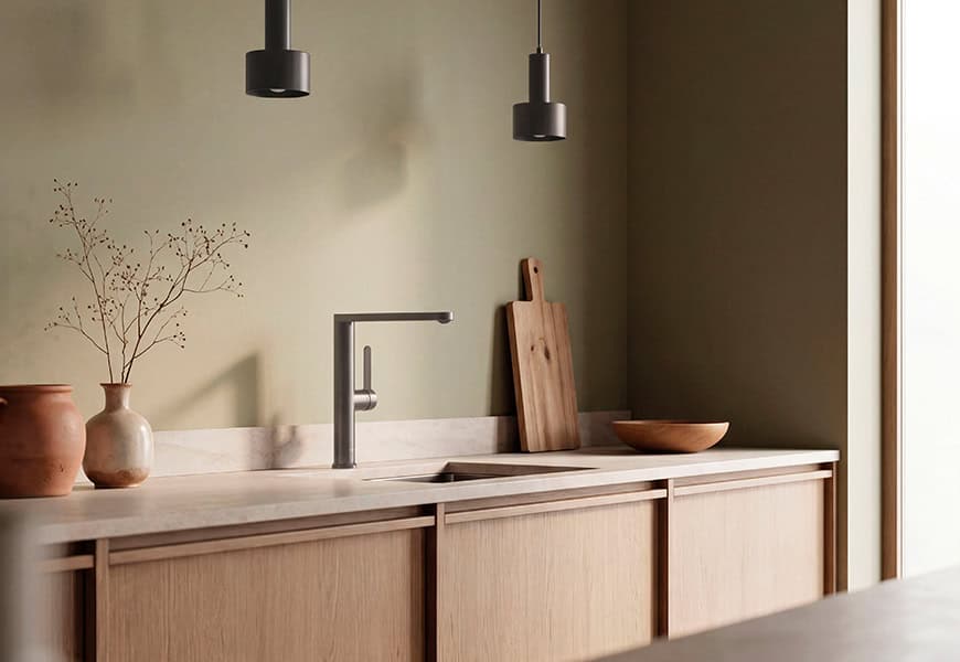 Grifo monomando de cocina en acabado grafito de la marca Tres, instalado sobre encimera de mármol en cocina de estilo contemporáneo